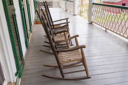 Old Wooden Rocking Chairs the on Porch of a Farmhouseの写真素材