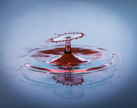 Blue and red drop of water splashing on the surfaceの写真素材