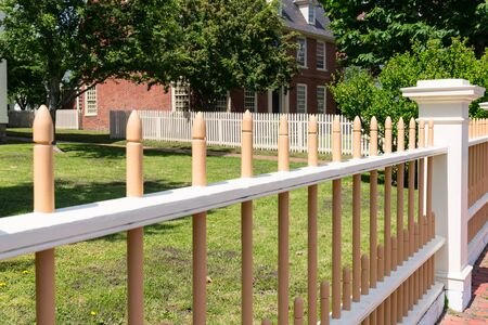 Wooden picket fence in front of historic home.の写真素材