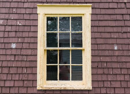 Old rustic yellow window frame with weathered peelingの写真素材