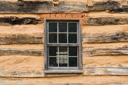Exterior of old weathered window in a rustic log cabinの写真素材
