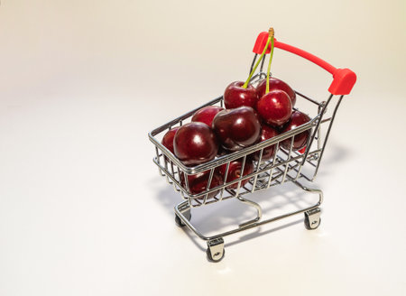 juicy large ripe red cherries in a small grocery cart at their supermarketの写真素材