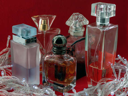 Different shape and color of the bottles of perfume on a red background.の写真素材