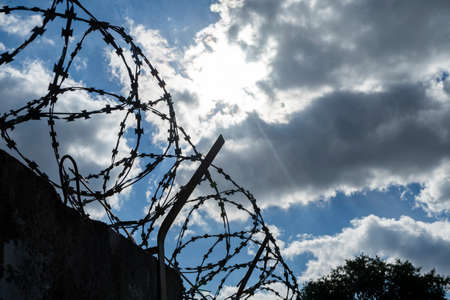 barbed wire on the fence against the blue sky