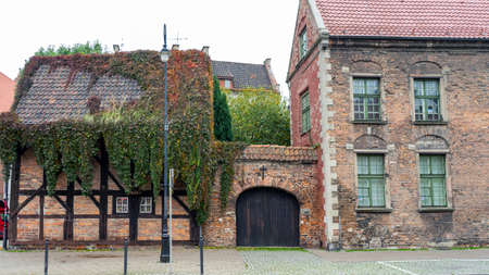 Old stone house in European style, covered with green ivy.