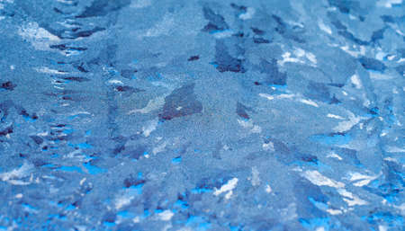 Frozen frost patterns on the glass. Winter ice pattern on glass. Blue Ice.