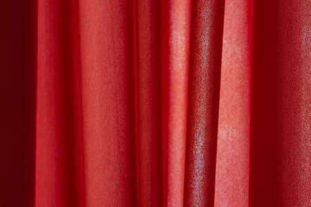 abstract background of luxury fabric or liquid silk texture of waves or wavy folds. Red cloth....