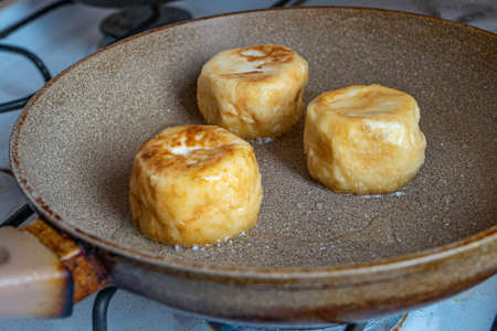 Cottage cheese pancakes, cheesecakes, ricotta fritters fried in a frying pan in hot oil.