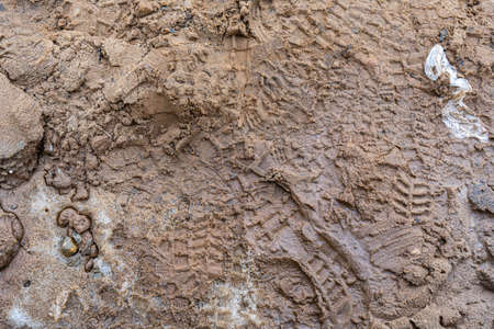 Background tracks from tires on clay off-road. Foot trace On the muddy area of nature.の写真素材