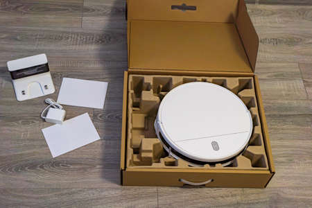 the first unpacking of the robot vacuum cleaner after purchase. Robot vacuum cleaner in an open...