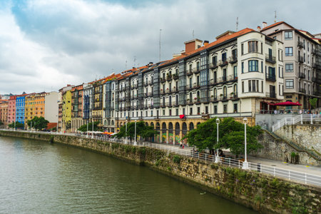 Bilbao, Spain - 08.06.2022: View city of Bilbao, Nervion river and its colorful architecture. Apartment buildings along the Nervion River, Bilbao, Spain.のeditorial素材
