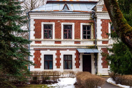 An old building with two floors of red brick and a tin roof.