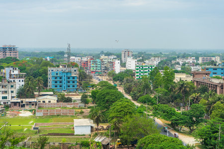 An aerial view of densely built-up area with various buildings of different sizes and colors, interspersed with patches of greenery under an overcast sky. Rajshahi, Bangladeshの写真素材