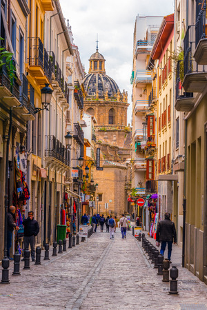Color full street of Granada, people walking. Iglesia de los santos justo y pastor in background.のeditorial素材