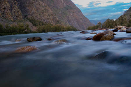 the rapid running of mountain rivers on a quiet summer evening on a long shutter speed