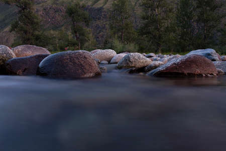 the rapid running of mountain rivers on a quiet summer evening on a long shutter speedの写真素材