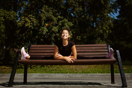 mom and daughter in sportswear on a sunny summer day on the embankment in the park doing fitnessの写真素材