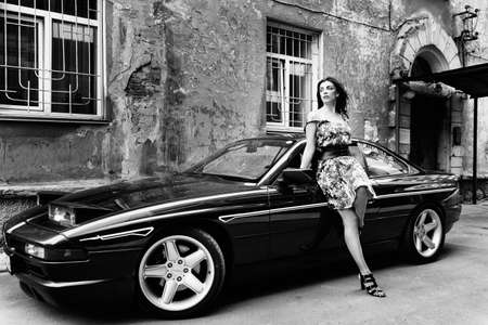 a young girl in playful poses, in jeans and a T-shirt playfully poses in a car on the side of the highwayの写真素材