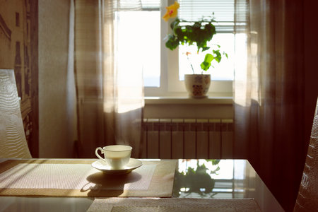 a cup of hot steaming coffee on a sunny morning on the kitchen tableの写真素材