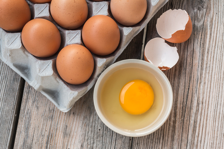 Eggs and Egg yolk in paper tray on woodの写真素材