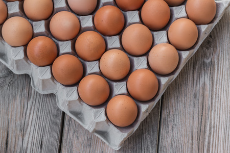 Eggs in paper tray on woodの写真素材
