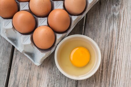 Eggs and Egg yolk in paper tray on wood
