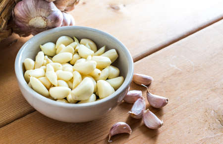 Garlic In White Bowl On Wood Tableの写真素材