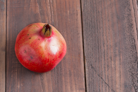 one pomegranate on wood tableの写真素材