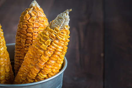 Dried Corn Stalk in bucket on wood tableの写真素材
