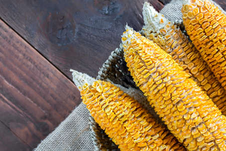 Dried Corn Stalk in basket on wood tableの写真素材