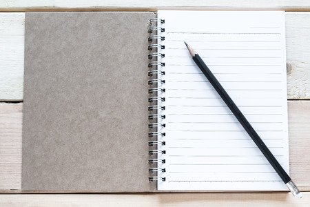 open notebook and pencil on wood tableの写真素材
