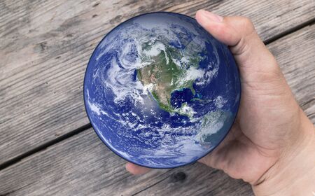 Man holding global in hand , Elements of this image furnished by NASAの写真素材