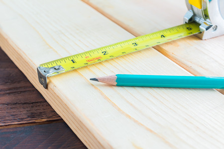 Measuring tape and pencil on a wood plank , Selective Focus , Build conceptの写真素材
