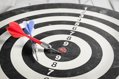 Red and blue dart arrow on dartboardの写真素材