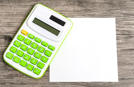 Calculator with Notepad on Wood Backgroundの写真素材