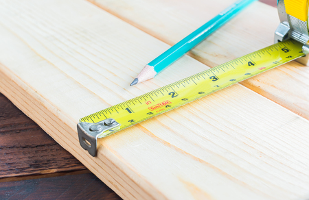 Measuring tape and pencil on a wood plank , Selective Focus , Build conceptの写真素材