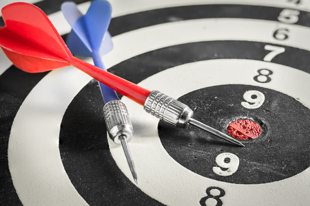 Red and blue dart arrow on dartboardの写真素材