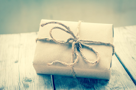 Vintage gift box brown paper wrapped with rope on wood background , vintage toneの写真素材