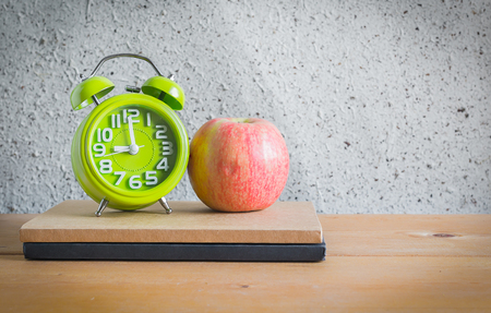 Clock , Apple and Notebook on Wood Table , Still Lifeの写真素材