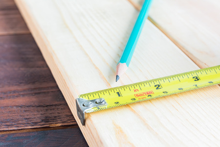 Measuring tape and pencil on a wood plank , Selective Focus , Build conceptの写真素材