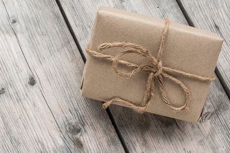 Vintage gift box brown paper wrapped with rope on wood backgroundの写真素材