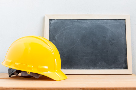 Helmet safety with chalkboard on wood tableの写真素材
