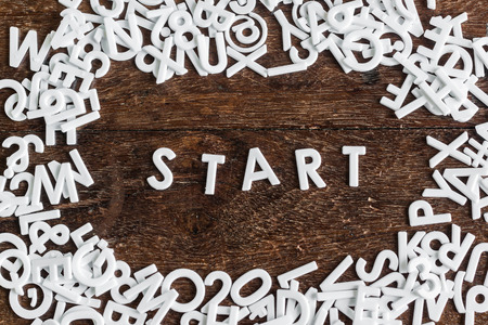 Letters START and english alphabet background with space on wood textureの写真素材