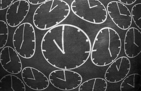Clock from chalk on black chalkboard background textureの写真素材