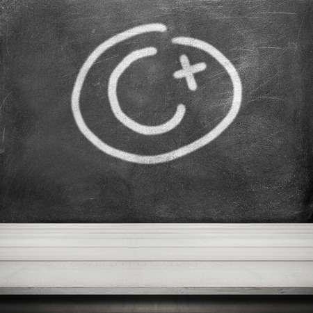 Grade c plus write on black chalkboard and wood table deskの写真素材