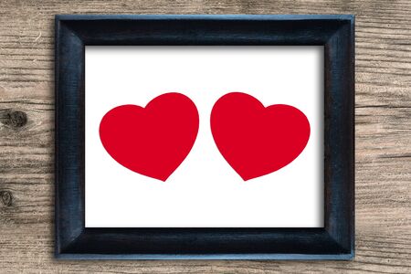Red heart in photo frame on wooden background , valentine conceptの写真素材