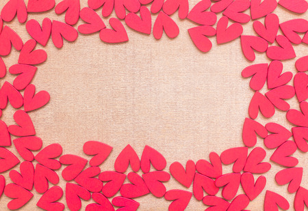 Many red wooden heart shape on wooden background , frame and space for textの写真素材