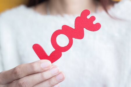 Woman hold words Love from wooden - people, relationship and love concept
