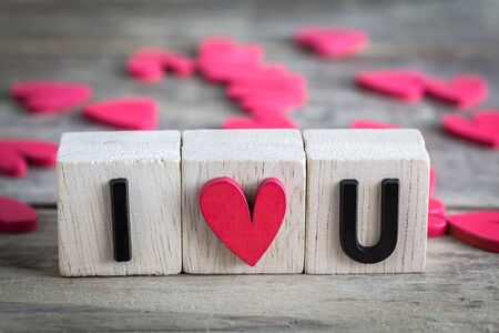 "I love you" in wooden cube with red heart shape on wood tableの写真素材
