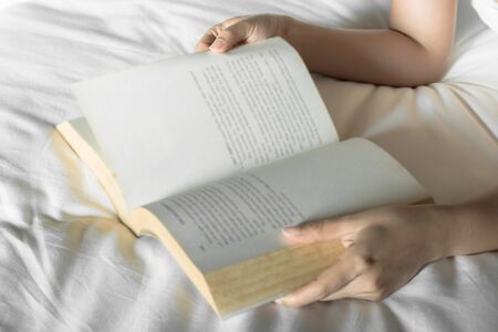 Woman read a book on bed , selective focusの写真素材